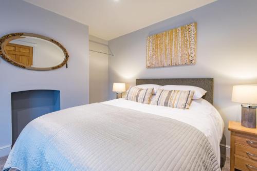 a bedroom with a white bed and a mirror at Customs House by Bloom Stays in Faversham