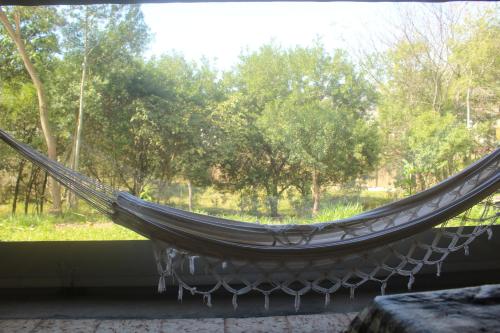a hammock in a room with a window at Pousada rotas e ritmos in Sao Paulo