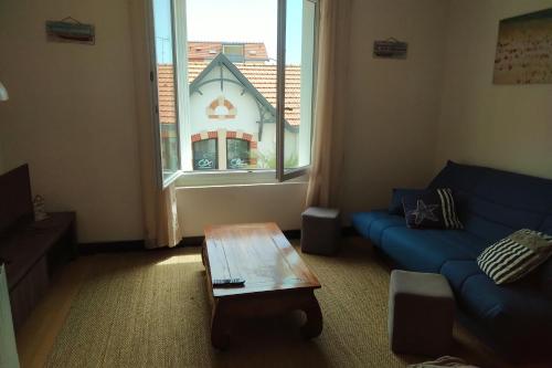 un salon avec un canapé, une table et une fenêtre dans l'établissement Le charme du centre ville et l ambiance plage, à Châtelaillon-Plage