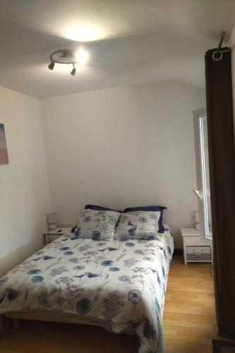 une chambre avec un lit avec une couette bleue et blanche dans l'établissement Le charme du centre ville et l ambiance plage, à Châtelaillon-Plage