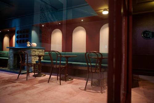 a bar with chairs and a table in a room at The Central Hotel Queenstown, A Naumi Chapter in Queenstown