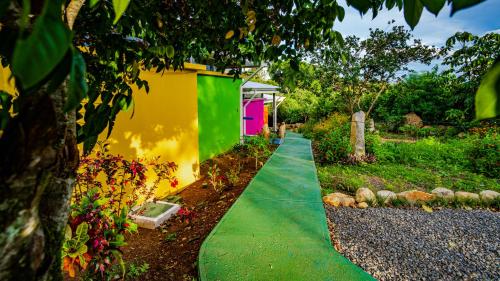 a green path in a garden with a house at Agutipaca Bungalows in Bagaces