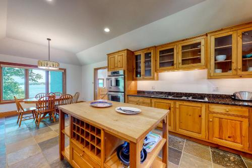 a kitchen with wooden cabinets and a dining room at Fanta Sea Shores in Wiscasset