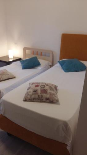 2 letti con cuscini blu in una stanza di Appartamento Mare Pital a Marina di Massa
