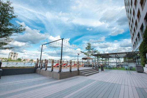 a boardwalk with a playground and a roller coaster at The Royal River Hotel in Bangkok