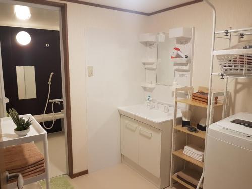 een witte keuken met een wastafel en een koelkast bij 旅籠まさら HATAGO MaSaRa in Tanabe