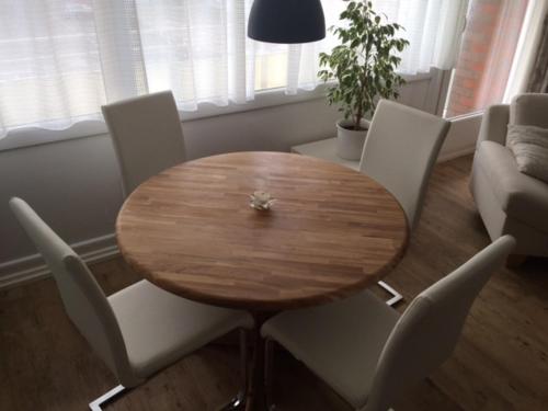 una mesa de madera y sillas en la sala de estar. en Haus Germania, en Westerland