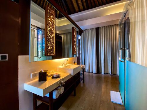 a bathroom with a sink and a mirror at Puri Hiromi Boutique Residence in Sanur
