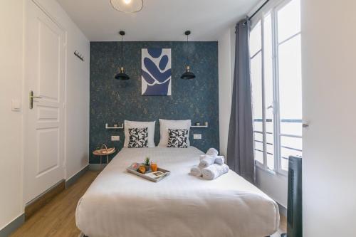 une chambre avec un grand lit blanc dans une pièce dans l'établissement WS Opéra - Rossini, à Paris