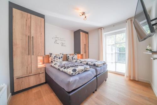 a bedroom with two beds and a large window at Südstrandhus Urlaub mit Hund Wohnung 1 unten in Borkum