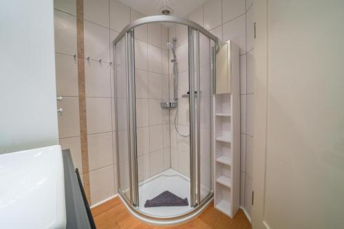 y baño con ducha y puerta de cristal. en Südstrandhus Urlaub mit Hund Wohnung 1 unten, en Borkum