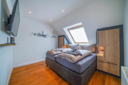 a living room with a couch and a television at Südstrandhus Urlaub mit Hund Wohnung 4 oben in Borkum