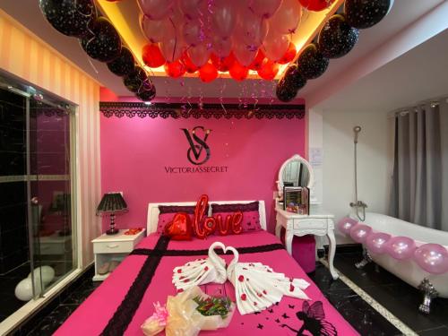 Dormitorio rosa con cama grande y techo de globo en Galaxy Hotel, en Ho Chi Minh