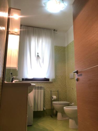 ペダーゾにあるAppartamento mare Marcheのバスルーム(トイレ、洗面台付)、窓が備わります。