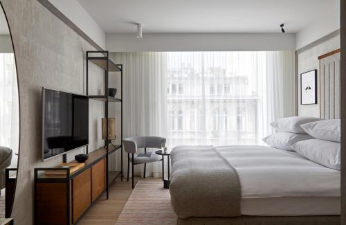 a hotel room with a bed, tv and a desk at PURO Warszawa Centrum in Warsaw