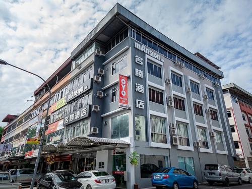 a building on a street with cars parked in front of it at Super OYO 90055 Mansion Inn in Sibu