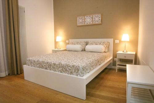 een slaapkamer met een wit bed met 2 lampen erop bij Corte Barone in Bari