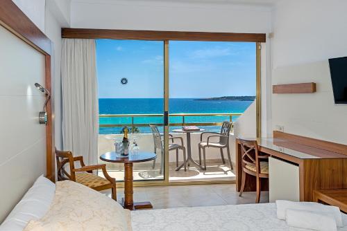 een kamer met een bed en uitzicht op de oceaan bij Hotel Biniamar in Cala Millor
