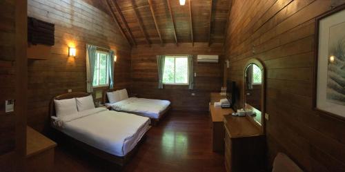 魚池郷にあるSun Moon Lake Youth Hostelのベッド2台とテレビが備わる客室です。