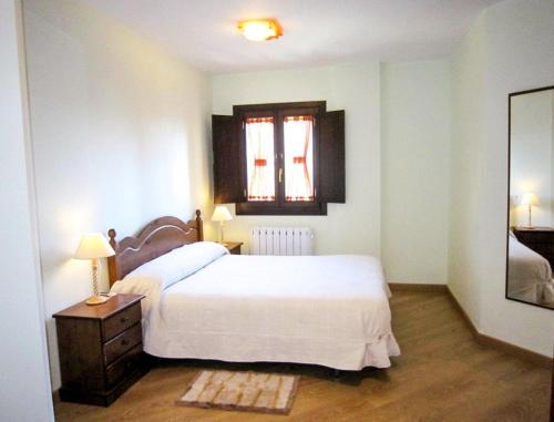 a bedroom with a white bed and a window at Apartamentos La Catedral in Roda de Isábena