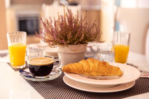 ルセにあるCentral Point Apartmentsのコーヒーとクロワッサンの朝食をテーブルの上に用意しています。