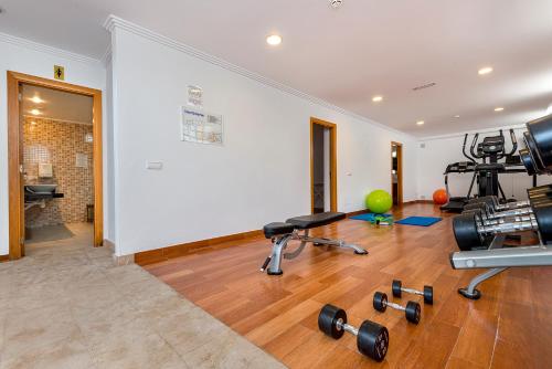 a gym with weights and exercise equipment in a room at Hotel Biniamar in Cala Millor
