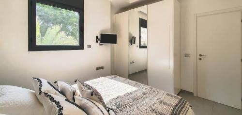 een slaapkamer met een bed met kussens en een raam bij BnBIsrael apartments - Rupin Ruby in Tel Aviv