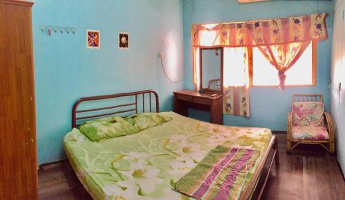a blue bedroom with a bed and a window at Greenleaf Guesthouse in Jerantut