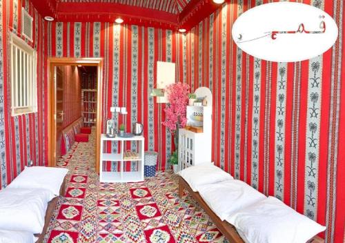 شاليهات شمس و قمر في الطائف: غرفة حمراء بجدران مخططة حمراء وبيضاء