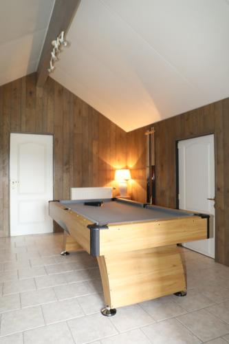 een pooltafel in een kamer met houten wanden bij Gîtes La Cigale et Le Grillon in Bouillon