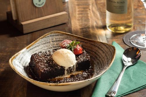 a bowl of chocolate dessert with ice cream and strawberries at The Coniston Inn - The Inn Collection Group in Coniston