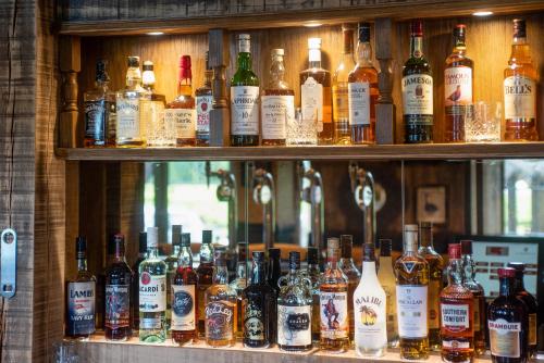 a bunch of bottles of alcohol on a shelf at The Coniston Inn - The Inn Collection Group in Coniston