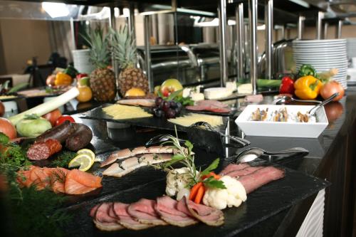 a buffet with meats and vegetables on a table at Grand Palace Hotel Hannover in Hannover