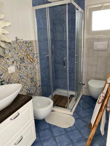 a bathroom with a shower and a toilet and a sink at Falso pepe Marzamemi in Marzamemi