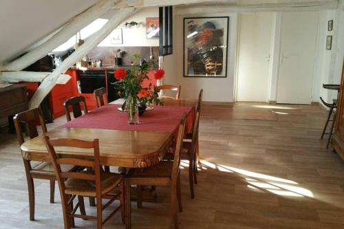 uma sala de jantar com uma mesa com uma toalha de mesa vermelha em APPARTEMENT DE CHARME AU COEUR DE NEVERS em Nevers