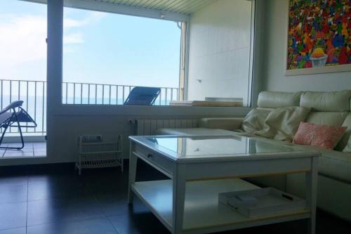 sala de estar con sofá y mesa de cristal en Vistas 180º al mar/puesta de sol/Free Wifi-parking, en Bakio