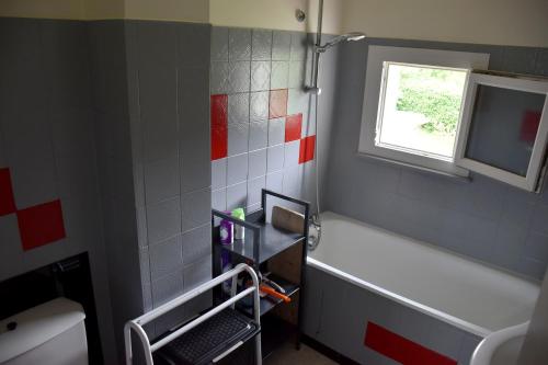 a bathroom with a bath tub and a window at Gîte 60M2 in Xonrupt-Longemer
