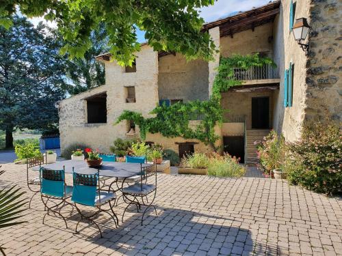 een patio met een tafel en stoelen voor een gebouw bij Les Demeures du Clos in Niozelles