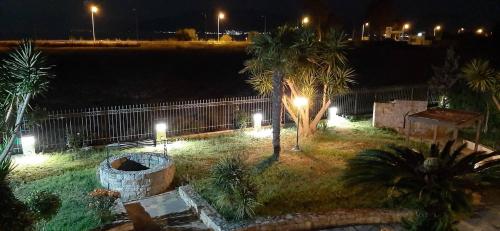 a park at night with palm trees and lights at The Villa of the Winds in Néa Kíos