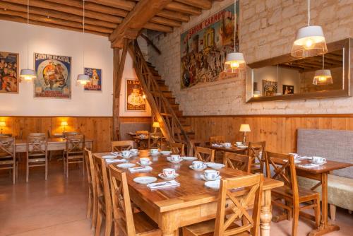 a dining room with a long wooden table and chairs at Le Domaine de Mestré, The Originals Relais in Fontevraud-l'Abbaye