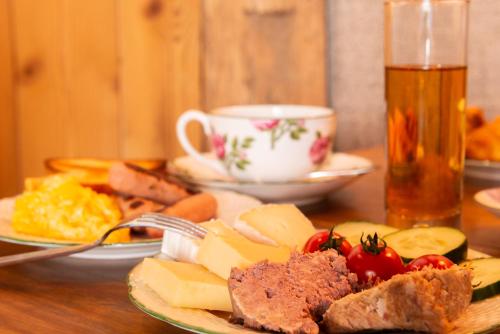 a table with plates of food and a cup of tea at Le Domaine de Mestré, The Originals Relais in Fontevraud-l'Abbaye