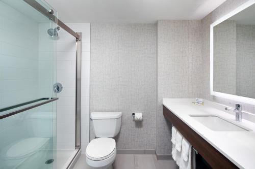 a bathroom with a toilet and a sink and a shower at Holiday Inn Express & Suites Halifax Airport by IHG in Enfield
