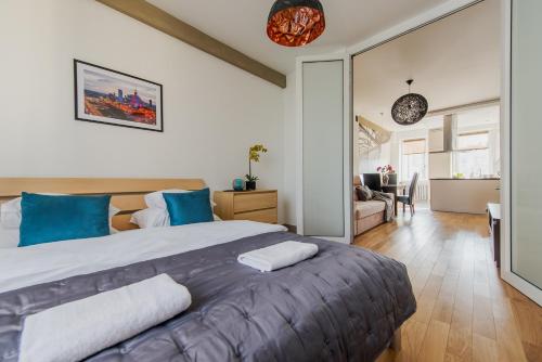 sypialnia z dużym łóżkiem i niebieskimi poduszkami w obiekcie Dworzec Centralny P&O Serviced Apartments w Warszawie
