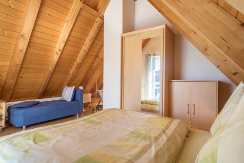 ein Schlafzimmer mit einem großen Bett und einem blauen Sofa in der Unterkunft Haus Sonnenschein in Eriskirch