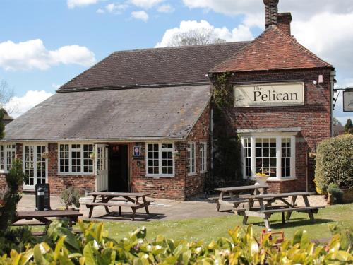 a building with picnic tables in front of it at The Pelican Inn in Froxfield