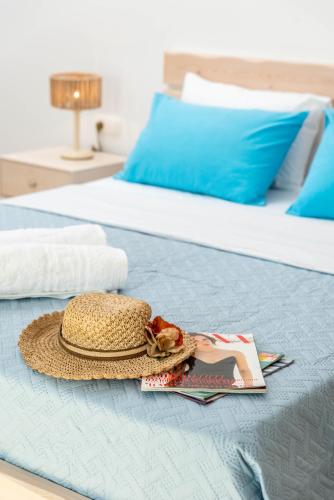 a straw hat and a magazine on a bed at Efkosmias Apartments in Pitsidia