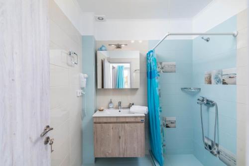 a bathroom with a sink and a shower at Efkosmias Apartments in Pitsidia