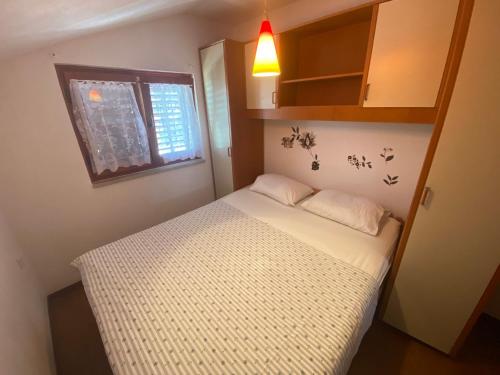 a small bedroom with a white bed and a window at Misho Apartments in Kruševo
