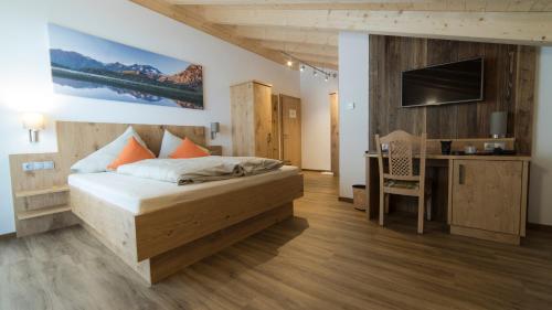 um quarto com uma cama, uma secretária e uma televisão em Gasthof Sportalm em Neustift im Stubaital