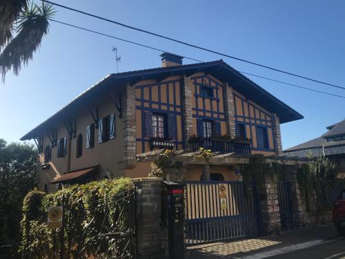 a house with a fence in front of it at Suites Mendibil Irun in Irún